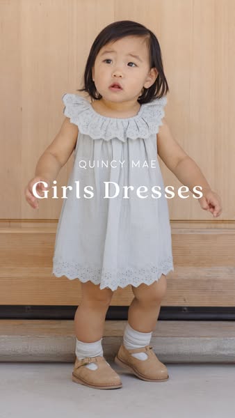 This image ad showcases a young child in a light blue dress from Quincy Mae. The focus is on the dress itself, highlight