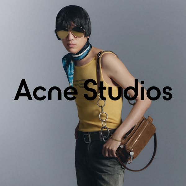 This image ad promotes Acne Studios, highlighting an overall fashion forward aesthetic and a featured handbag. The ad sh