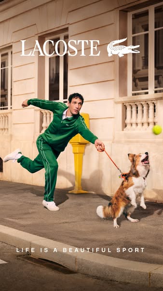 A man and a dog are on the street running. The man is wearing a green track suit and white sneakers and the dog is mediu