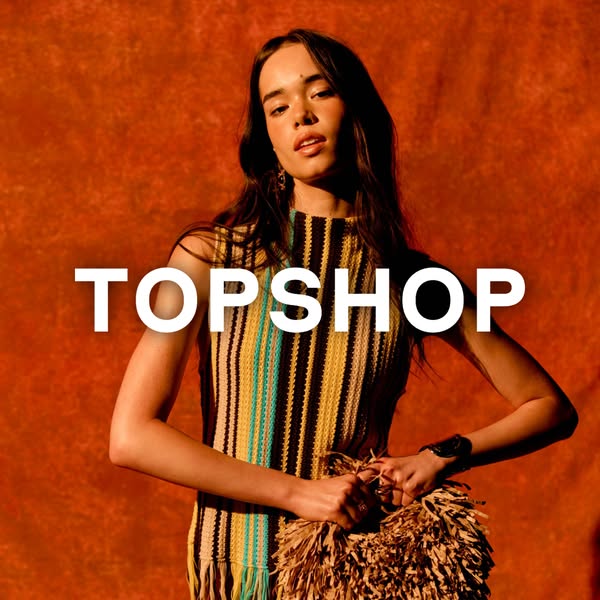 This Topshop image ad features a model wearing a Topshop top and holding a Topshop bag, with the brand name emblazoned a