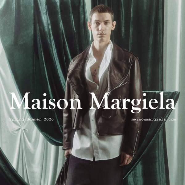 An advertisement by Maison Margiela, showcasing a model wearing the brand's jacket and promoting their website.