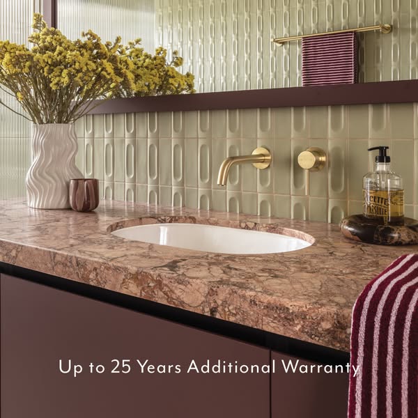 This image ad for bathroom fixtures features a stylish bathroom counter with a modern gold faucet, decorative vase, and 