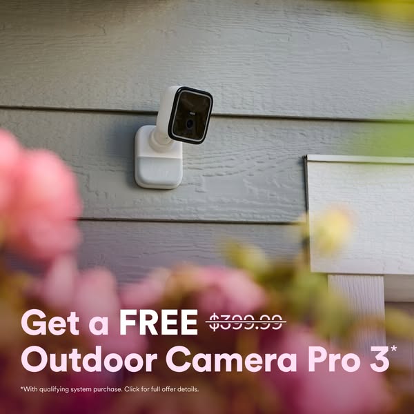 The ad promotes the Outdoor Camera Pro 3, offering it for free with a qualifying system purchase. The camera is mounted 
