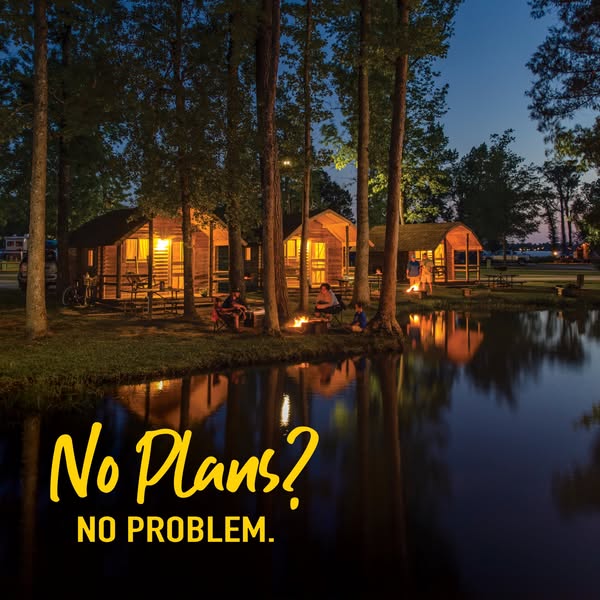 The image ad showcases a campground at night with cabins lit up, a firepit, and a reflective lake. The tagline conveys t