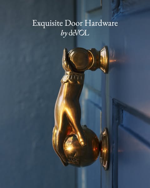 An image showcasing door hardware by deVOL. The image features an ornate, golden door knocker shaped like a hand graspin