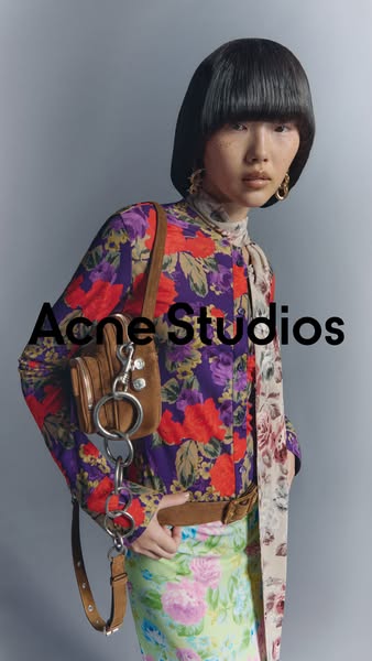 This ad showcases the Acne Studios brand and a brown leather purse, with the intent of drawing the viewer in with the ae