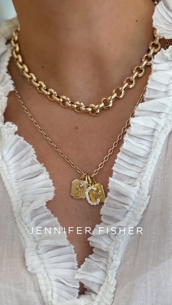 This ad showcases Jennifer Fisher jewelry, specifically two necklaces, on a person.