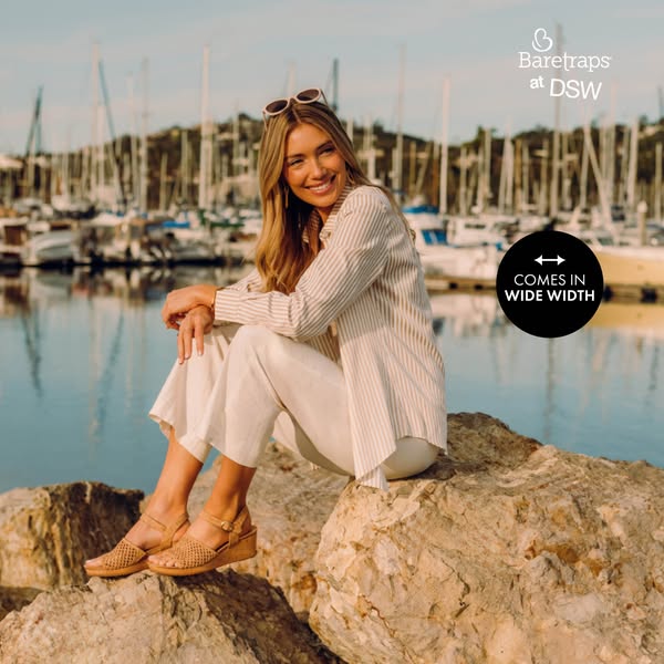 An image ad promoting Baretraps sandals at DSW. It features a woman sitting on rocks in a harbor setting, wearing the ad