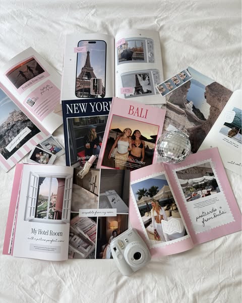 An image showing open travel journal books with photos and text about travel locations, a perfume bottle and a Polaroid 
