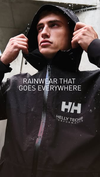 This ad showcases a man wearing a Helly Hansen raincoat in a rainy urban setting, emphasizing its suitability for all co