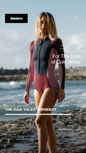 This Finisterre image ad features a woman wearing the KAIA YULEX® SWIMSUIT in front of a rocky beach. The ad aims to app