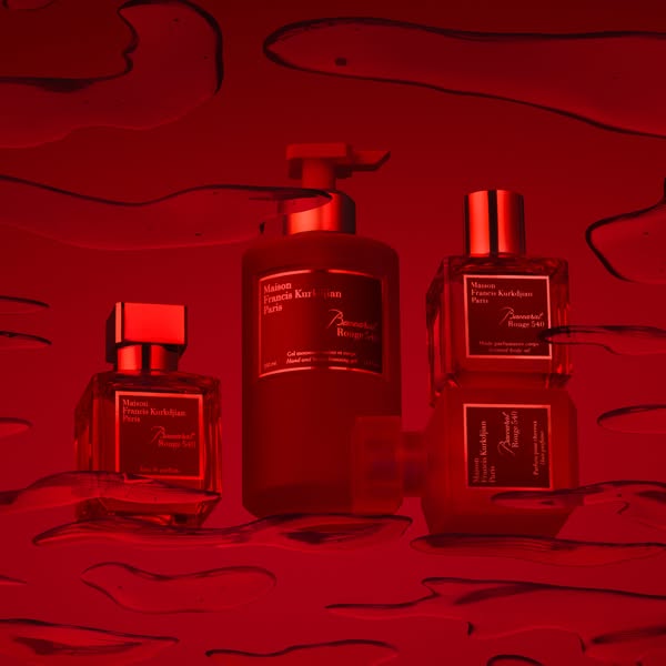 This image features a selection of Baccarat Rouge 540 products in a monochromatic red setting. The composition emphasize