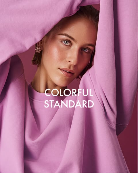 This ad showcases the apparel brand Colorful Standard, featuring a model wearing a pink sweatshirt from the brand.