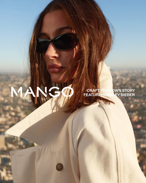 A Mango ad featuring Hailey Bieber. The ad is advertising the brand Mango and features Hailey Bieber wearing a cream-col