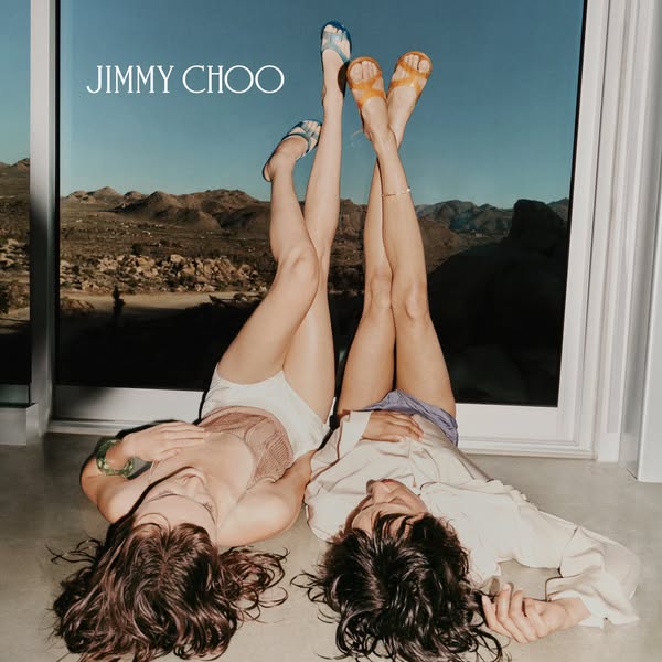 This ad features two women lounging indoors by a window with a view of a desert landscape. The women are shown wearing s