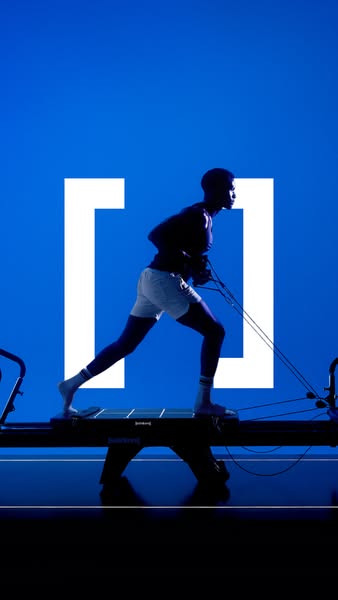 This ad features a man using a pilates machine. The ad is visually striking with a blue background and a silhouetted fig