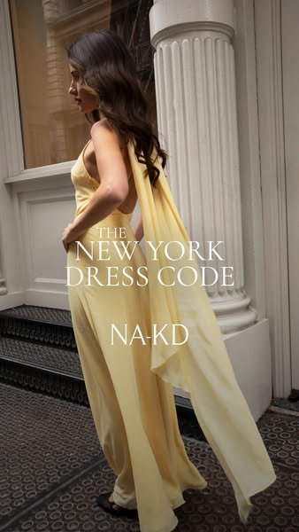 Image ad featuring a model wearing a light yellow dress in a city setting, promoting NA-KD's clothing line and sugge