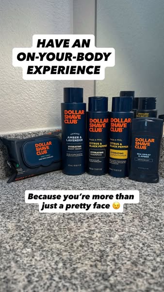 This ad showcases a range of Dollar Shave Club body care products on a bathroom counter. The ad uses the headline 'H