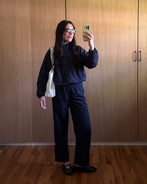 This ad features a woman wearing a track suit. She is taking a selfie in front of a wooden paneled wall. The photo is ta