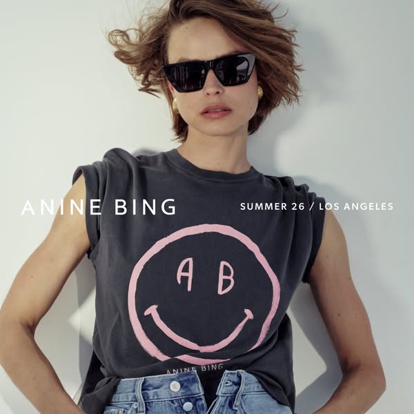 A campaign ad for Anine Bing clothing, featuring a female model wearing the brand's vintage-inspired t-shirt. The ae
