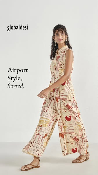 This image ad features a stylish woman in a Global Desi printed jumpsuit, suitable for airport travel, set against a cle