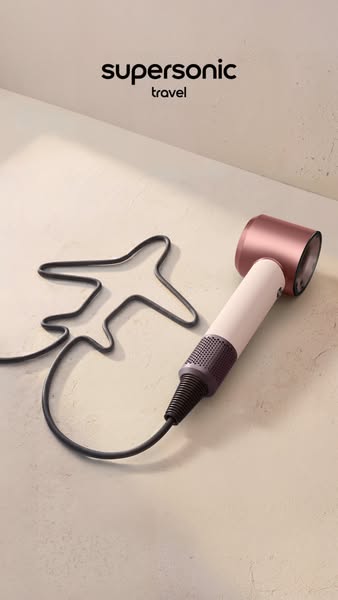 This is a minimalist image ad showcasing the Dyson Supersonic hair dryer for travel, emphasizing its compact design and 