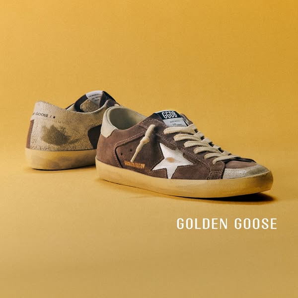 This ad showcases two pairs of Golden Goose sneakers on a yellow background. The brand name is displayed at the bottom.
