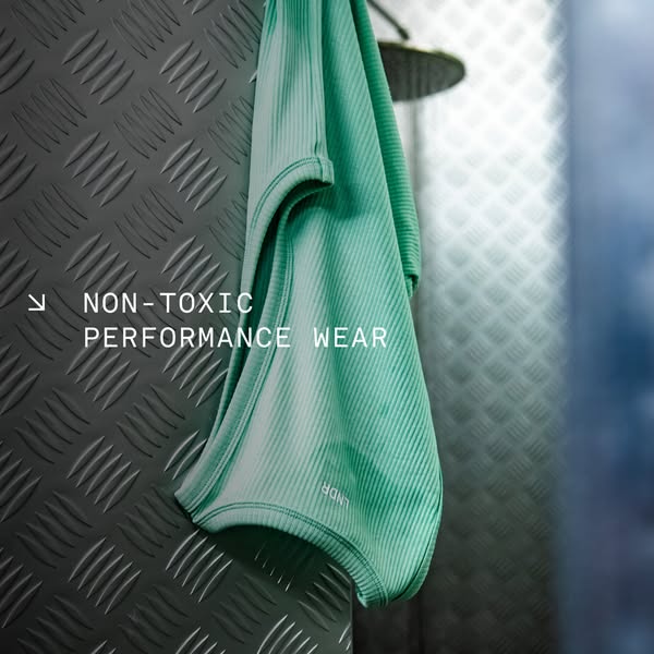 This image ad features a teal-colored t-shirt hanging next to a shower head, emphasizing its non-toxic and performance w