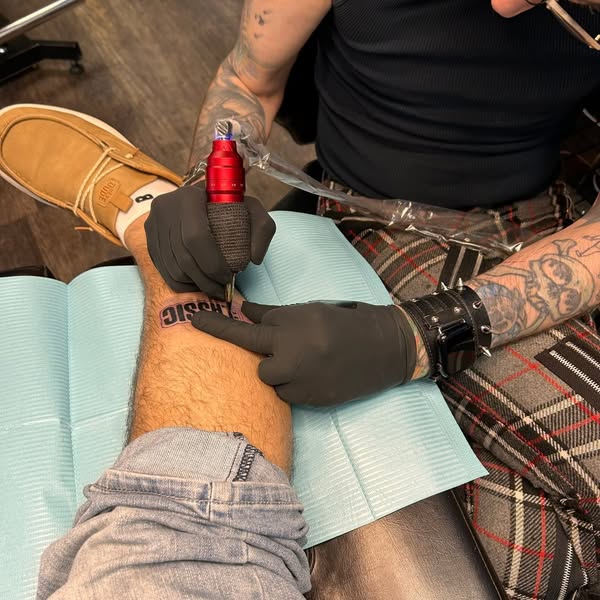 This ad shows a person getting a tattoo on their forearm with the word "Classic".