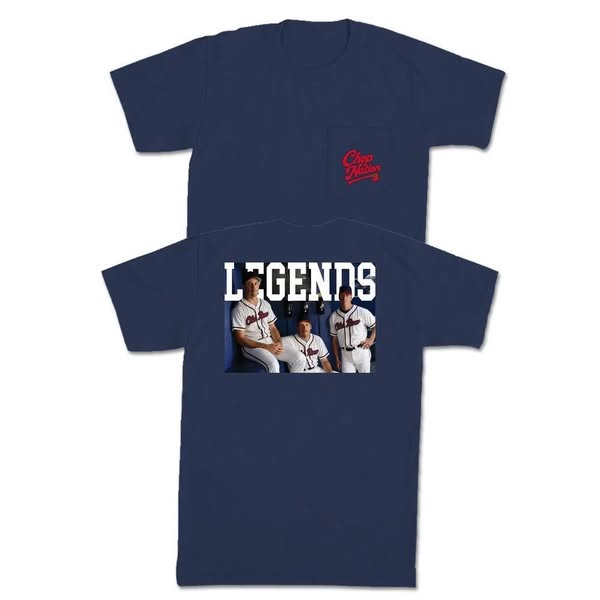This ad features a navy blue t-shirt with a baseball theme. The shirt has a pocket on the front left with a team logo on