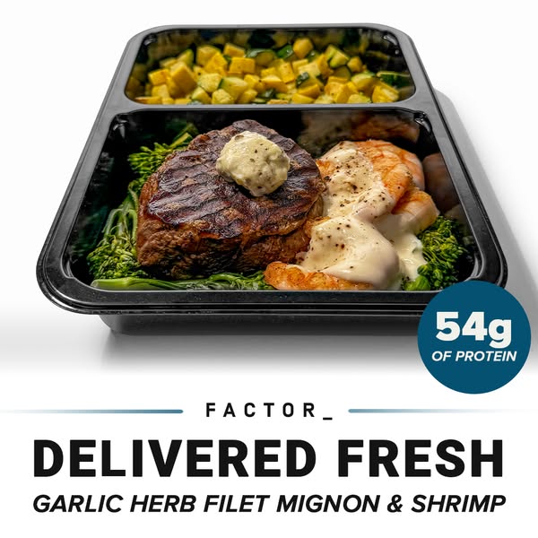 The image is an advertisement for Factor_ pre-made meals. It showcases the Garlic Herb Filet Mignon & Shrimp option 