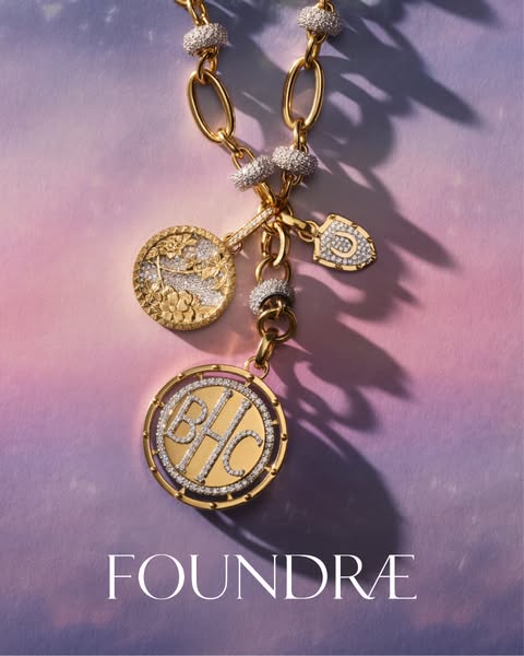 This ad showcases a gold chain necklace with several gold and diamond encrusted charms. The product is set against a col