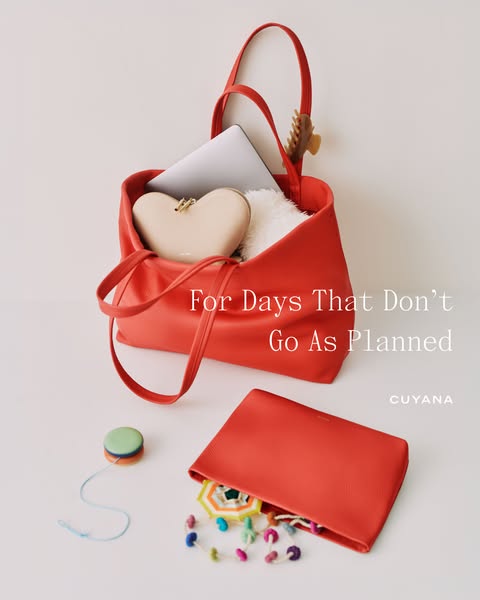 This ad features a red Cuyana tote bag with items spilling out of it. The headline says, "For Days That Don't G