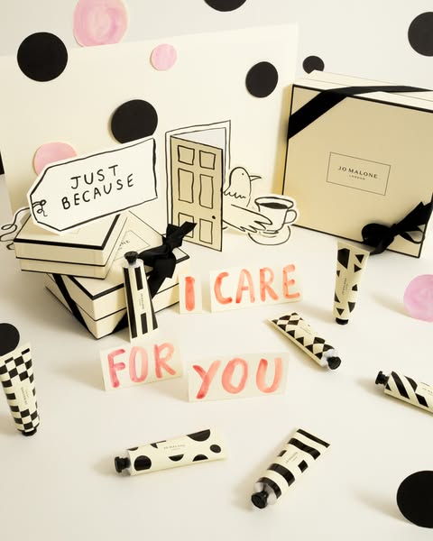 Flatlay of Jo Malone hand creams in decorative packaging, arranged with paper cut-out props and a background in a matchi