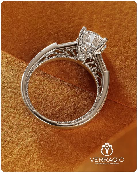 This ad features a close-up of a Verragio engagement ring set against a textured gold background.