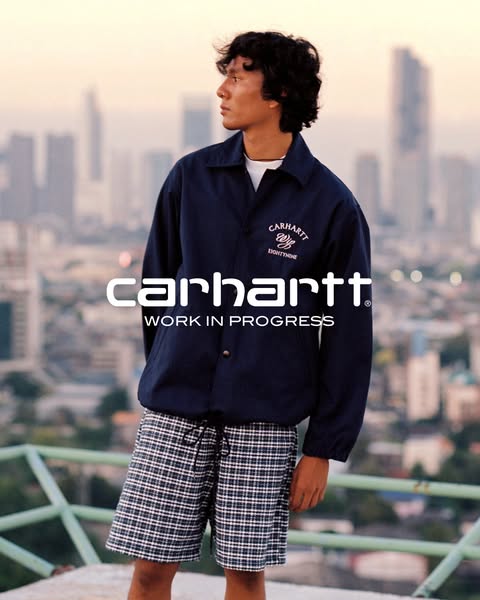 This ad showcases a man wearing a Carhartt jacket and shorts with the brand logo prominently displayed and lifestyle ima