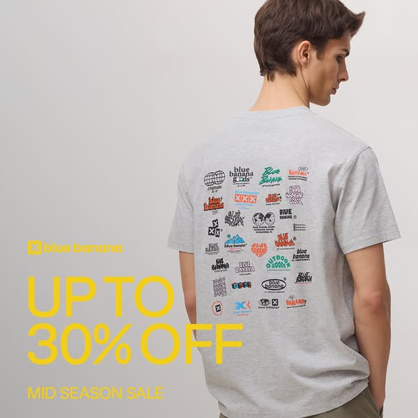 The image ad showcases a light gray Blue Banana t-shirt with multiple brand logos printed on the back. The ad highlights