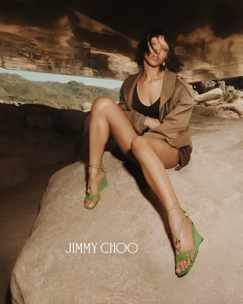 This image ad features a woman wearing Jimmy Choo shoes, positioned in a desert scene.