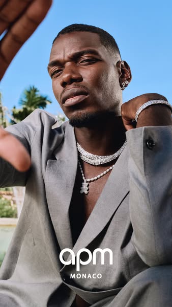 This image ad showcases APM Monaco jewelry on a male model, Paul Pogba, in an outdoor setting, emphasizing luxury and li