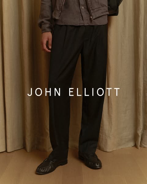 The ad showcases a John Elliott garment.