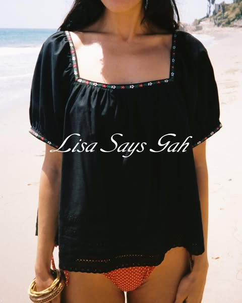 This ad is for Lisa Says Gah and features a person wearing a black top while standing on a beach.