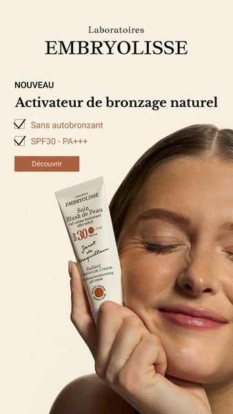 A close up shot of a woman who is wearing the Embryolisse Soin Blush de Peau product on her face. The ad features the pr