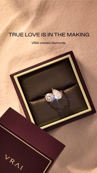 An engagement ring with two different stone shapes sits in a jewelry box. The ad focuses on love and commitment, invitin