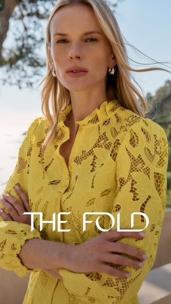 This ad for The Fold features a woman wearing a yellow dress with intricate, lacy detailing. The photograph is taken at 