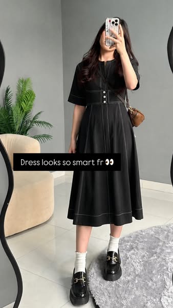 This ad showcases a woman wearing a black midi dress with white contrast stitching, paired with white socks and black lo