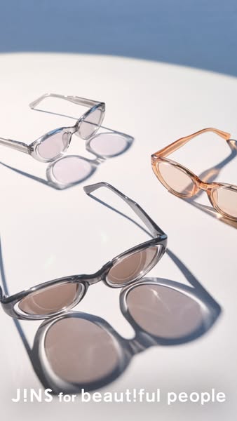 Ad showcasing three pairs of JINS sunglasses on a white surface.