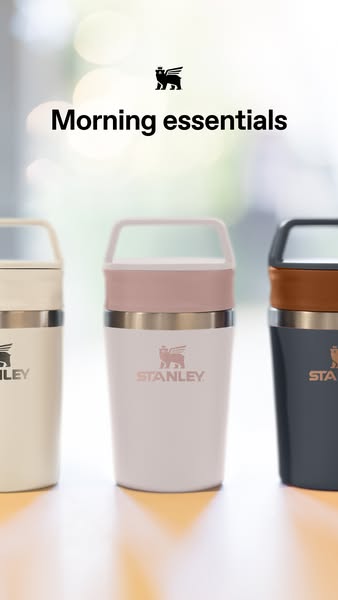 This image ad features three Stanley insulated mugs in a range of colors on a reflective white surface. The copy reads &