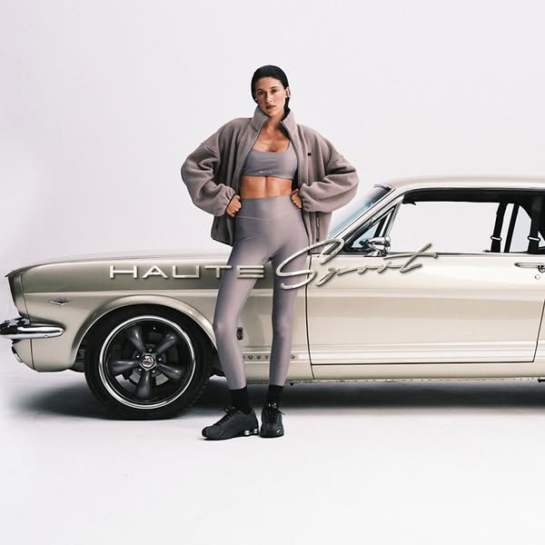 This ad features an image of a model wearing Haute Sport activewear next to a vintage car. The image serves to showcase 