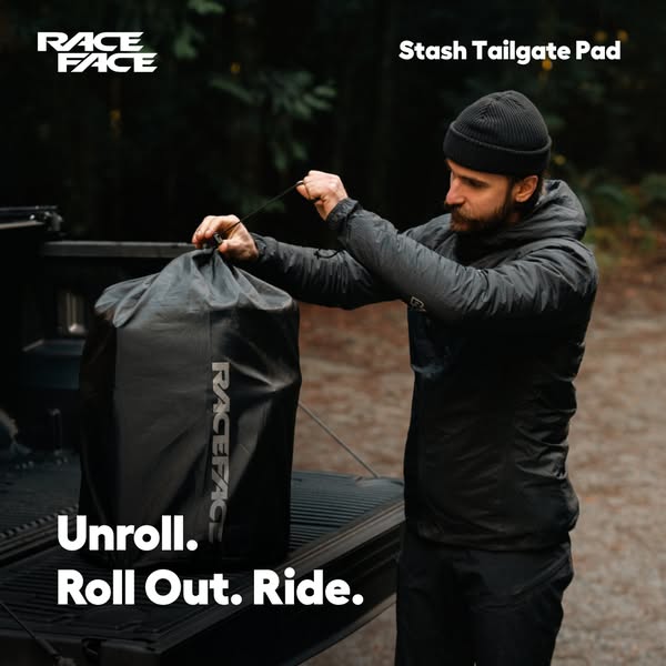 This ad features a man standing at the back of a truck, opening a bag that contains a Stash Tailgate Pad from Race Face.