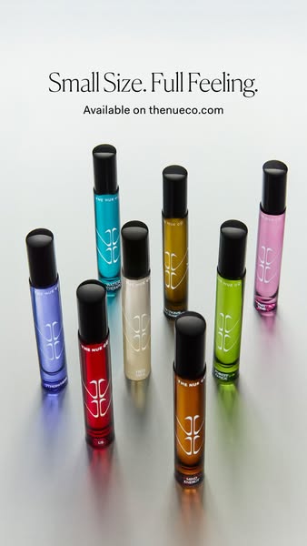 An image ad featuring eight small roll-on bottles of THE NUE CO fragrances. The ad presents the fragrances as compact an